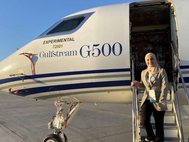 UC Davis student Duha Bader stands on steps of an airplane
