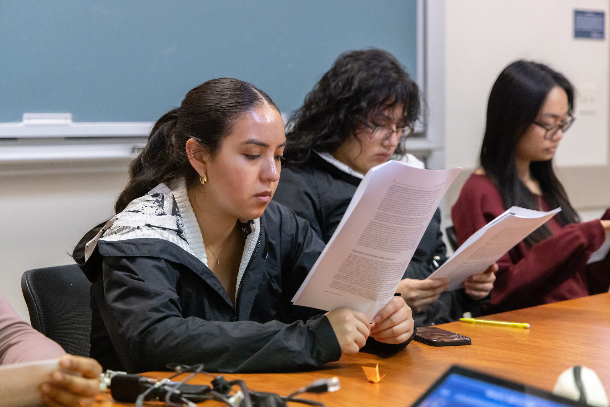 Students at a table reading packets