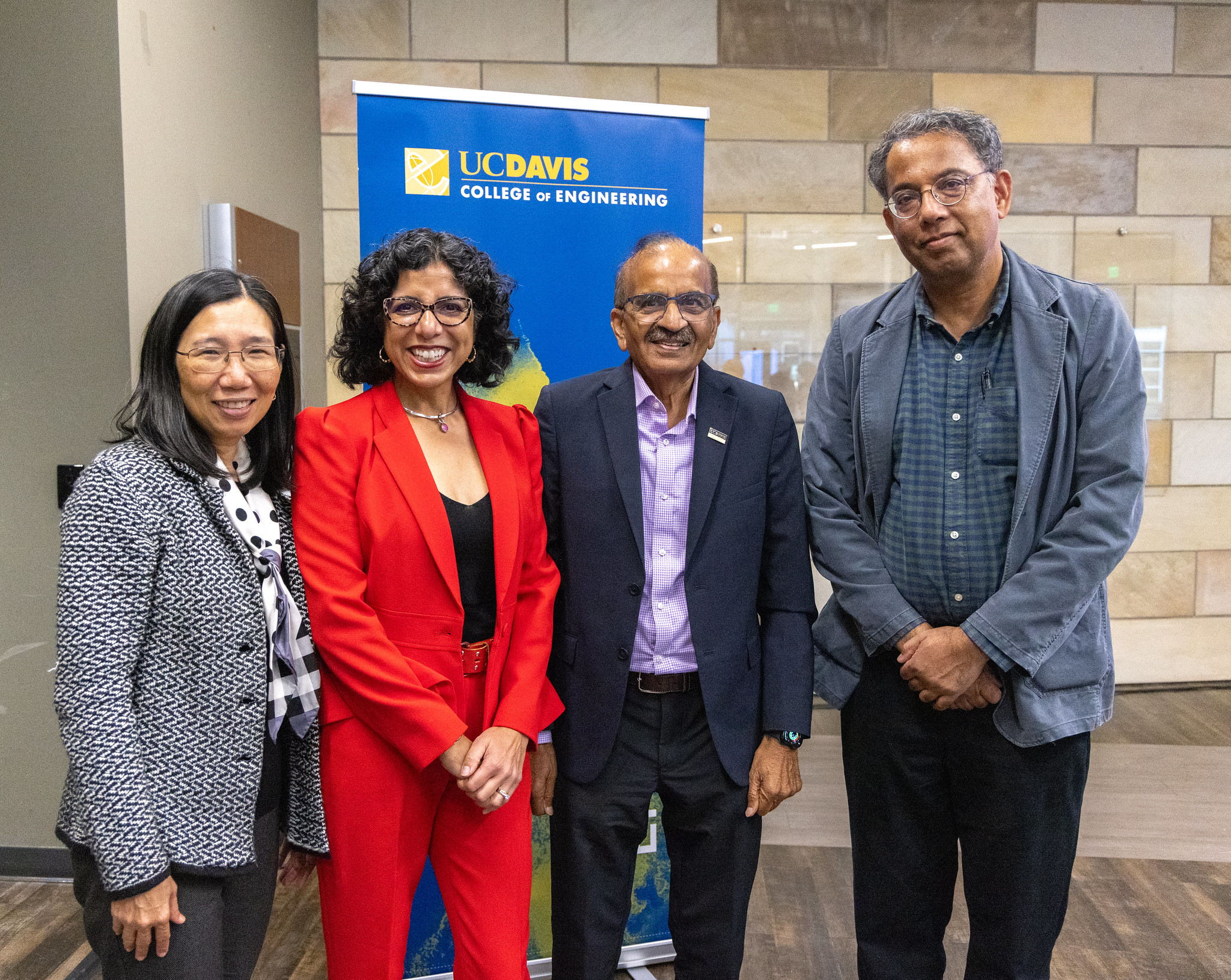 Three faculty stand with Prem Jain