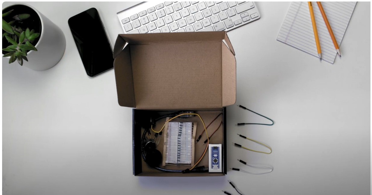 Cardboard box on a desk that has various wires and STEM materials inside