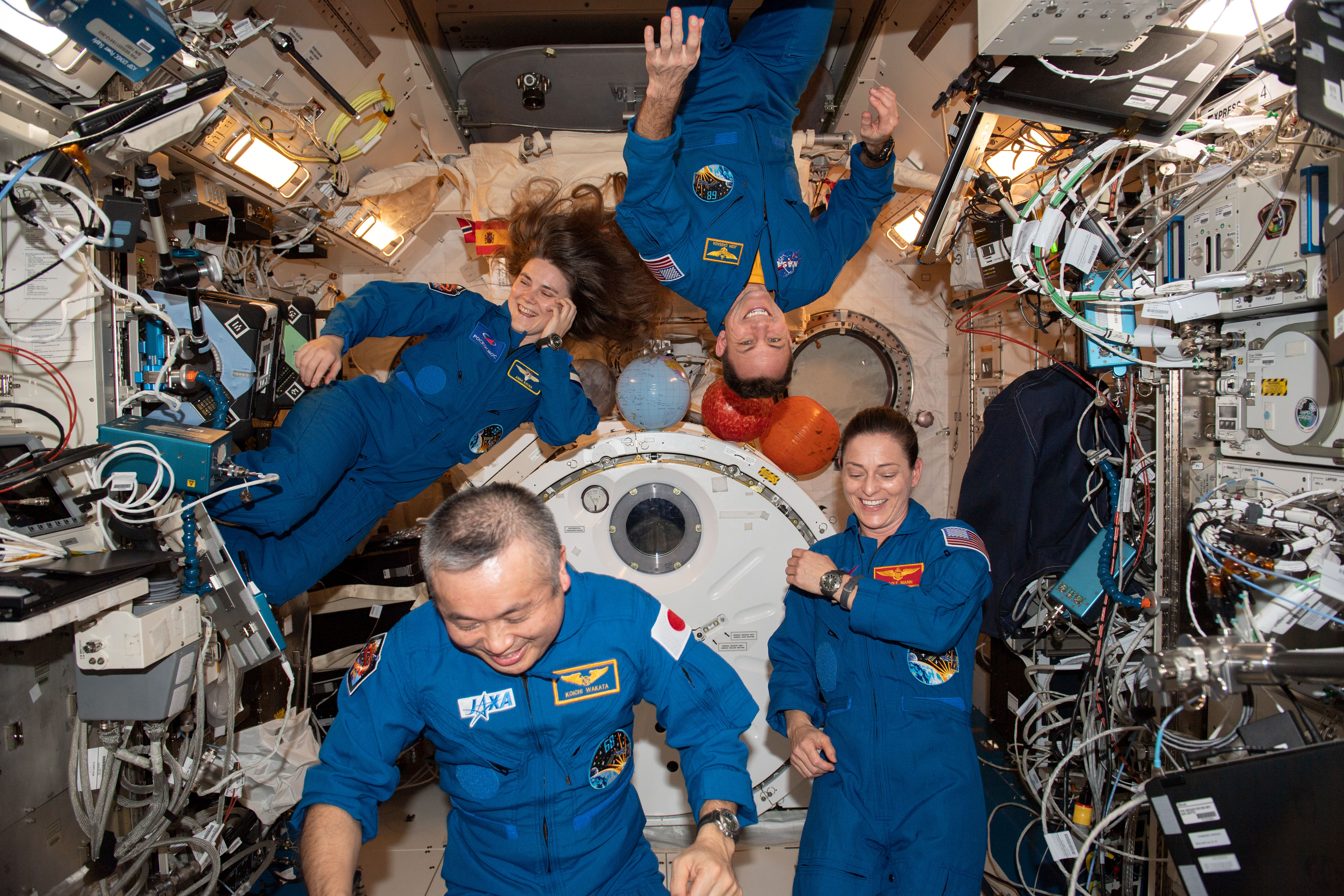 A group of NASA astronauts float in a space craft