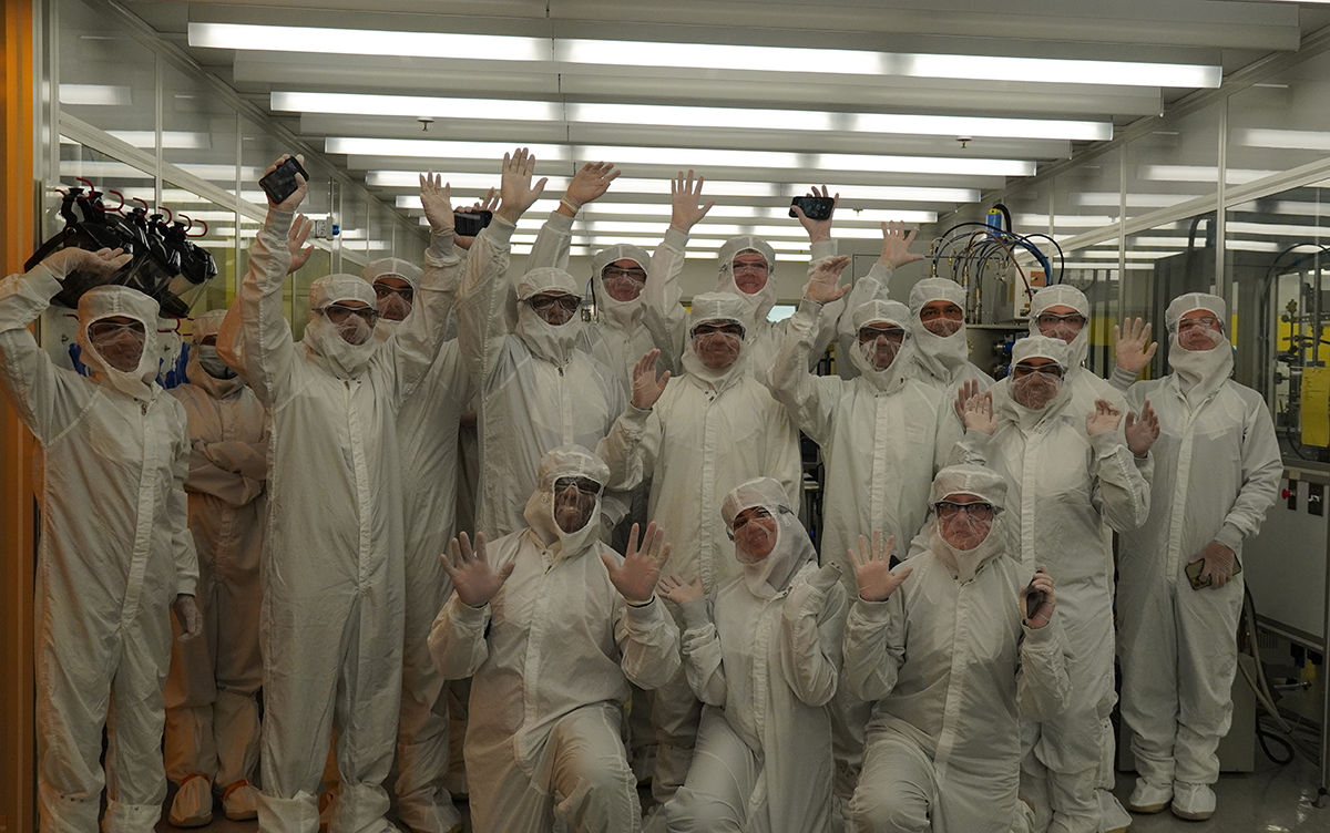 Group of students in white cloth suits in a lab