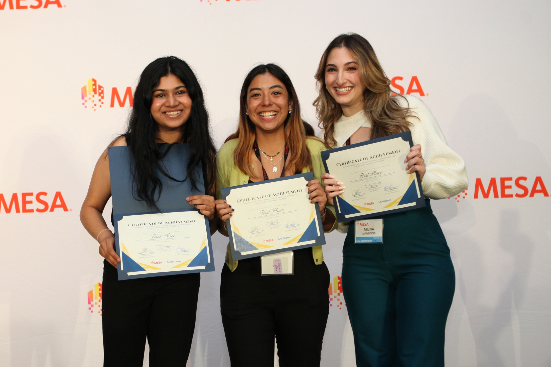 Three people stand together at a conference