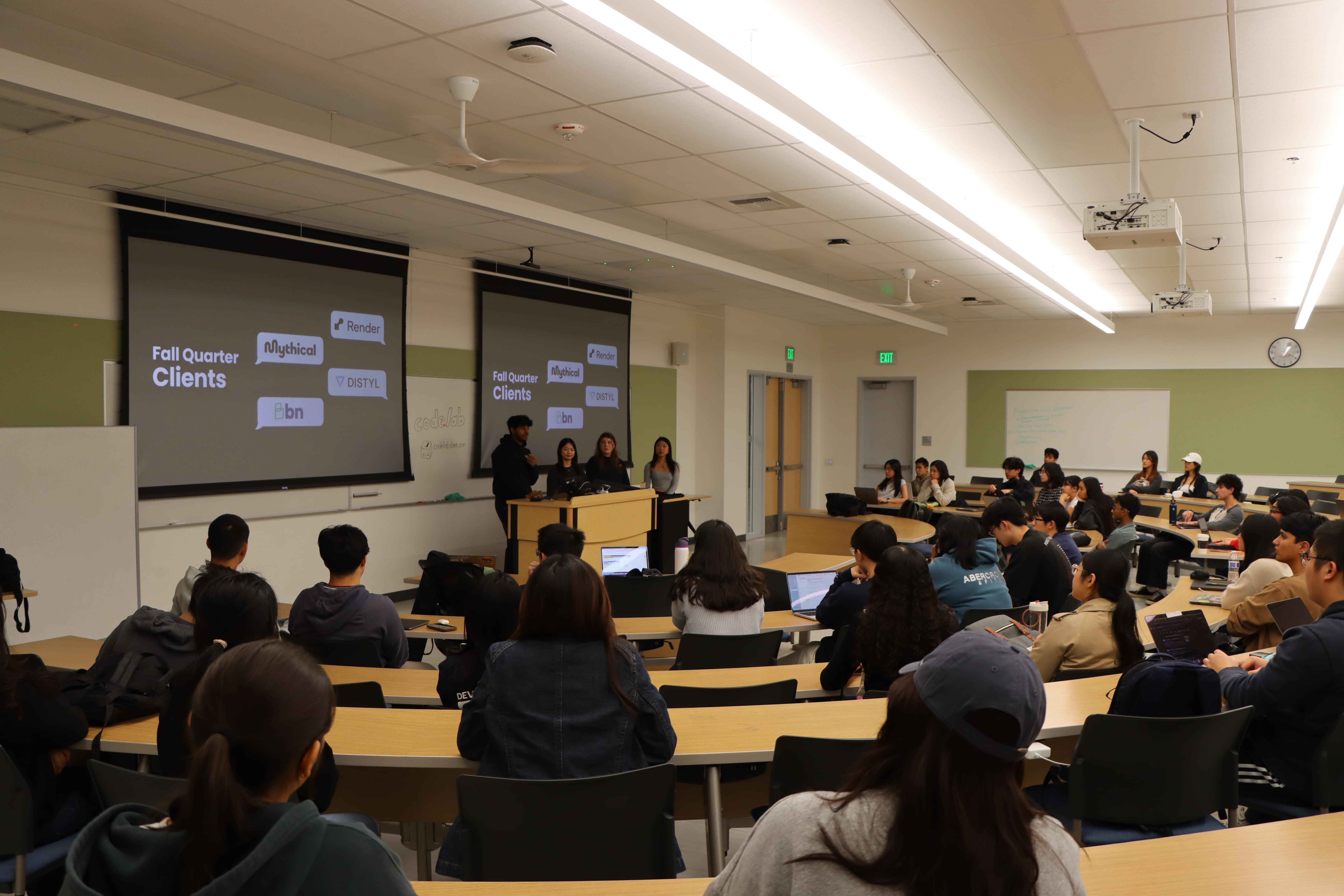 Several students at desks watching a Codelab presentation