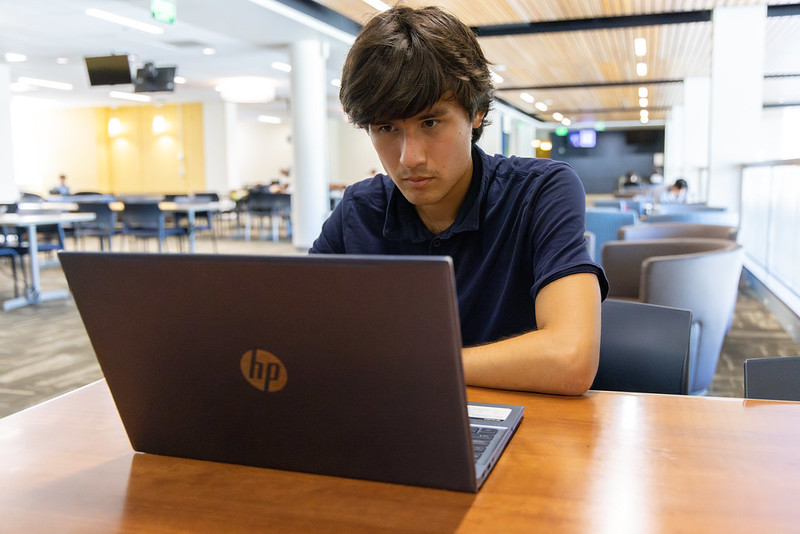 Graeber sits at a table, working on a laptop at UC Davis