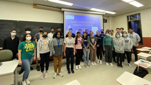 Society of Manufacturing Engineers students pose for group photo in front of a projector screen