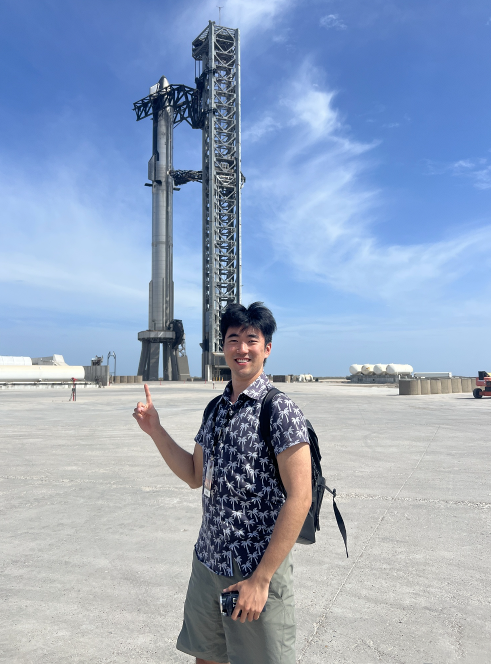 Toby Li pointing to a rocket in the background
