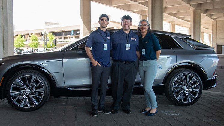 Three UC Davis members standing in front of a Cadillac LYRIQ EV 