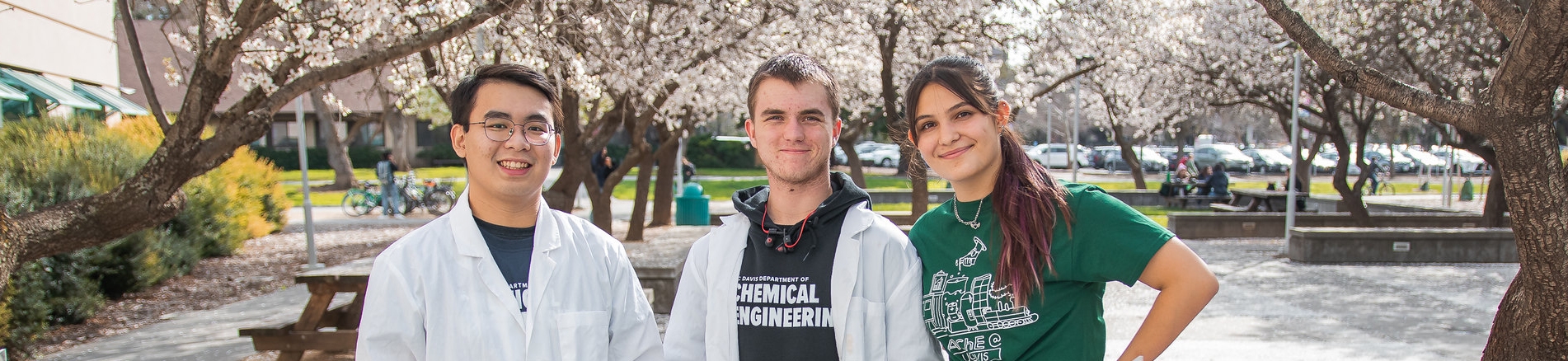 Three engineering students stand outside for a portrait