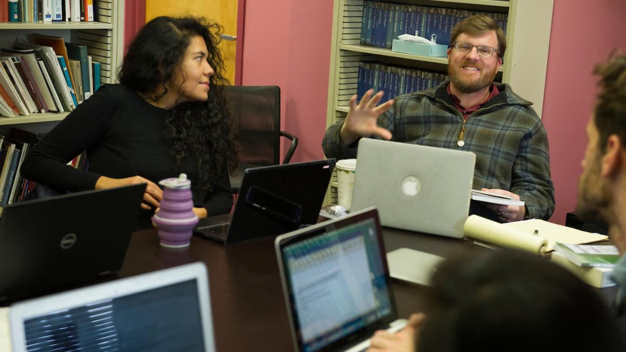 UC Davis Associate Professor of English Michael Ziser and students sit at a table with laptops