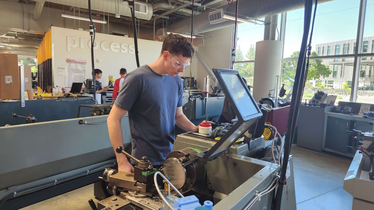 Student works on machinery in the Engineering Student Design Center at UC Davis