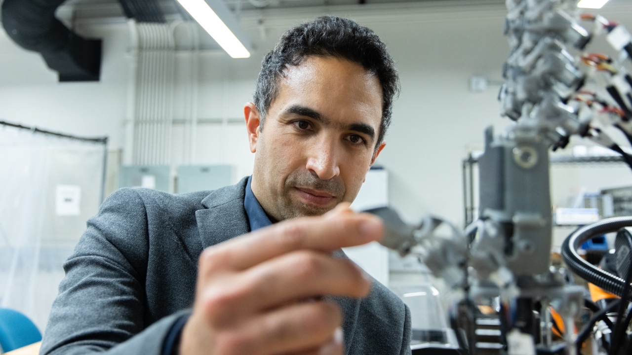 Iman Soltani holds something in lab