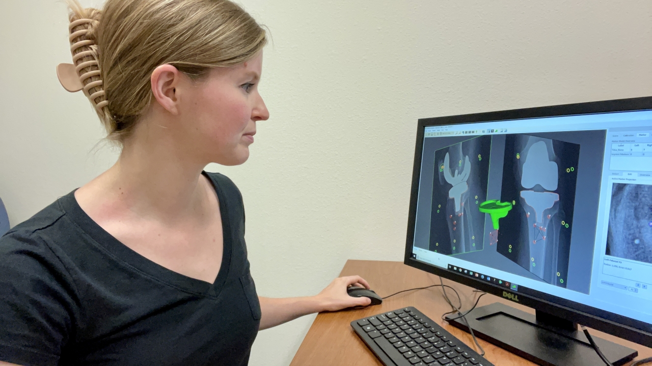 UC Davis grad student Abby Niesen sits at a desk with computer screen showing 3D imaging