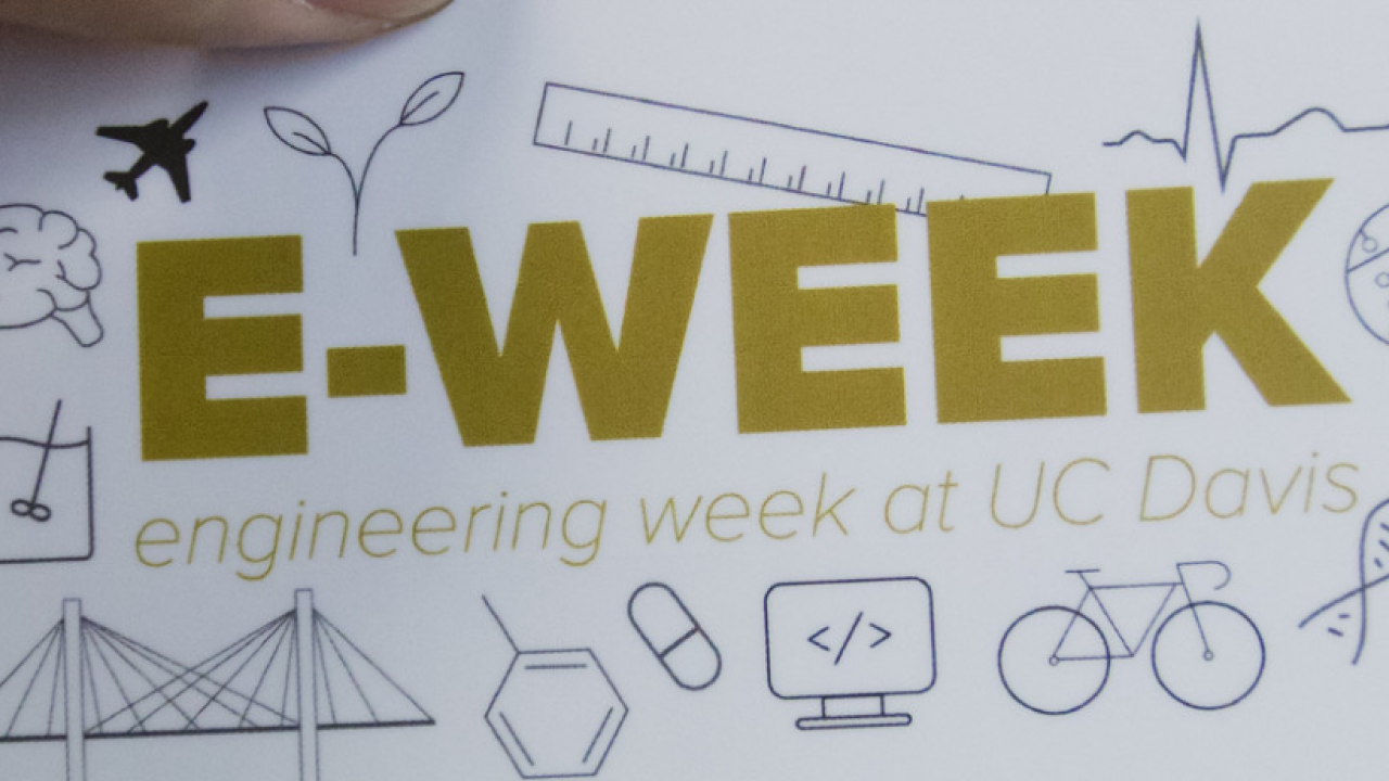 A white card with yellow lettering spelling "E-WEEK"
