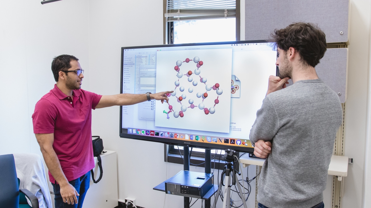 Two researchers in a classroom looking at a screen