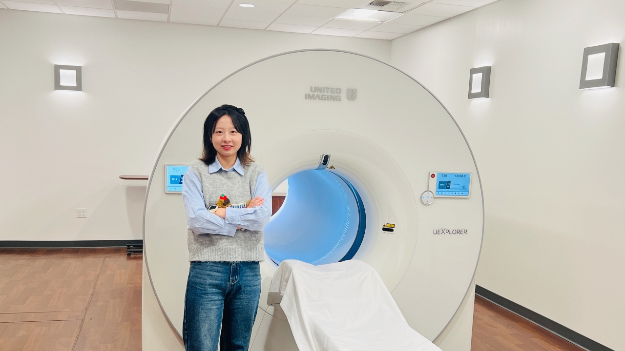 Xiaoyu Duan stands before a uEXPLORER total-body PET scanner