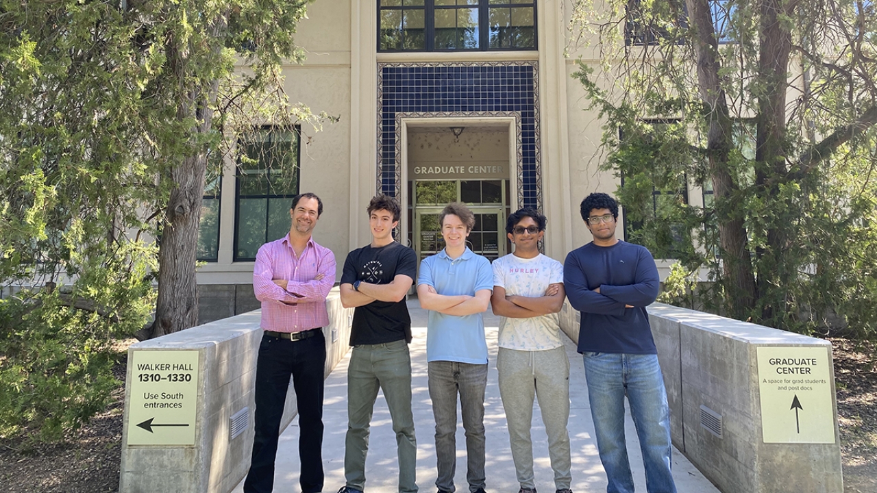 Five people stand outside of an engineering building on the UC Davis campus