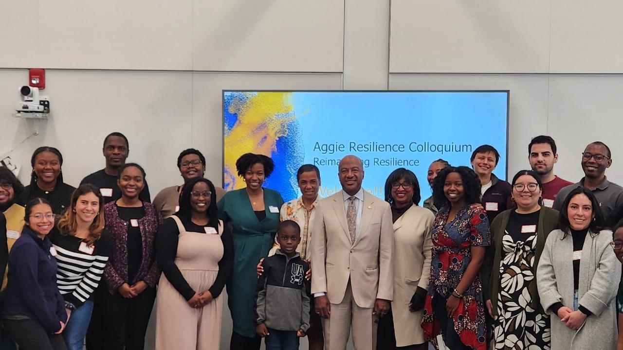 Many people standing in front of a screen that says "Aggie Resilience Colloquium"