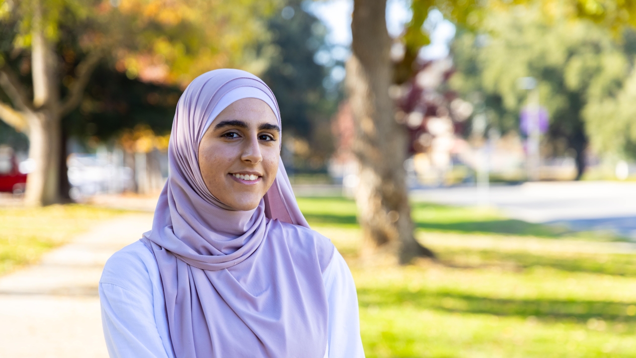 A photo of Rawan Dirhalleh with greenery in the background