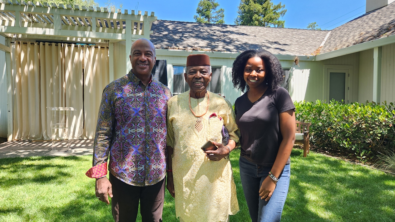 Three people stand outdoors