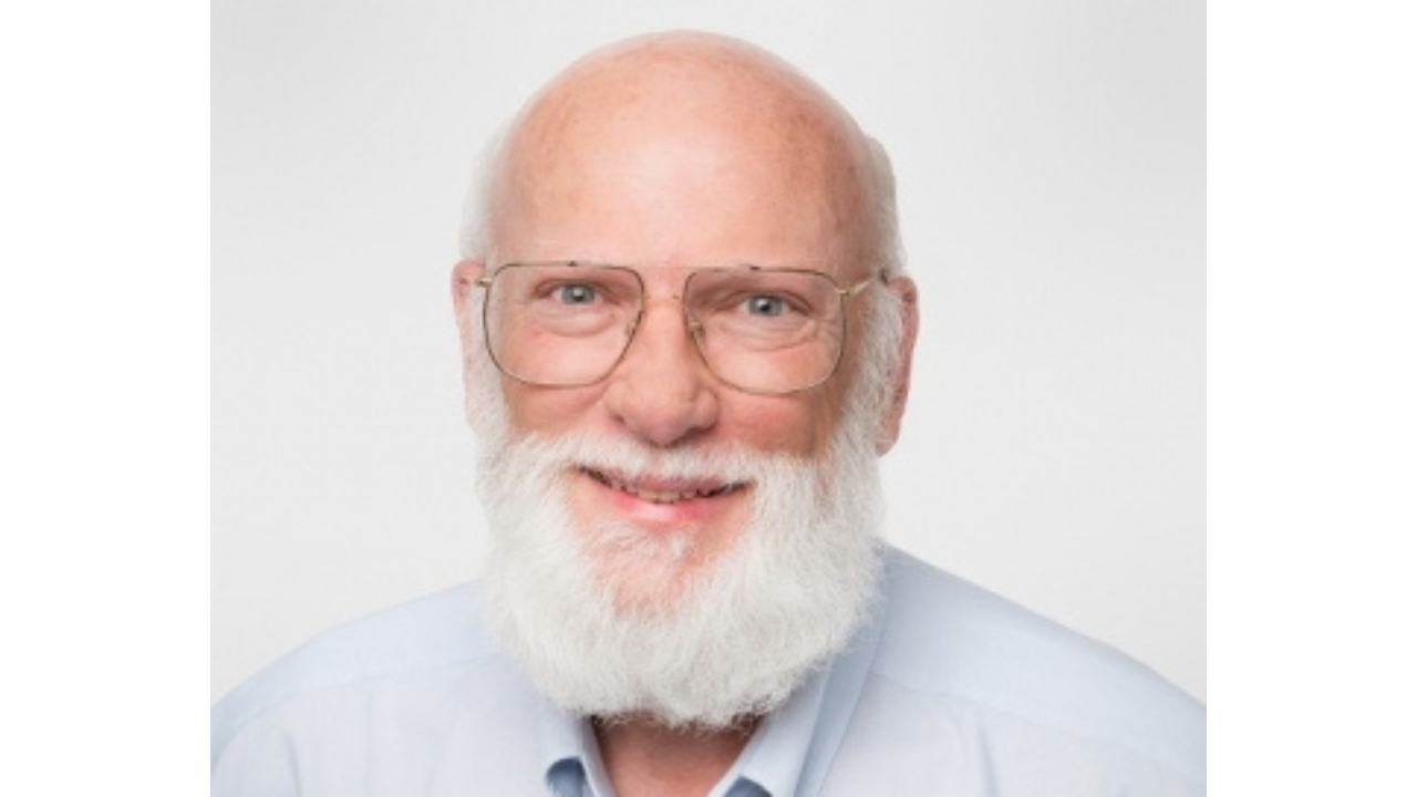 Rick Johnson with glasses and a white beard against a light background.