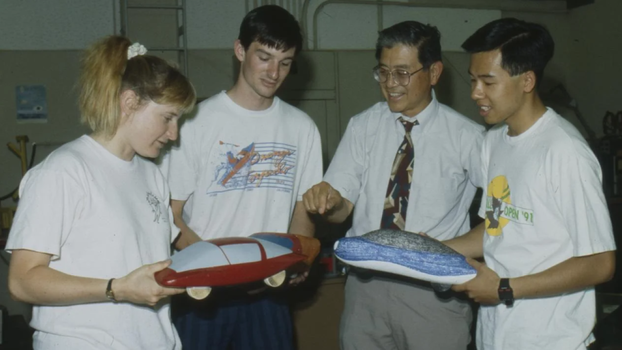 Professor Andrew Frank and three students look at small model cars in 1992 photo.