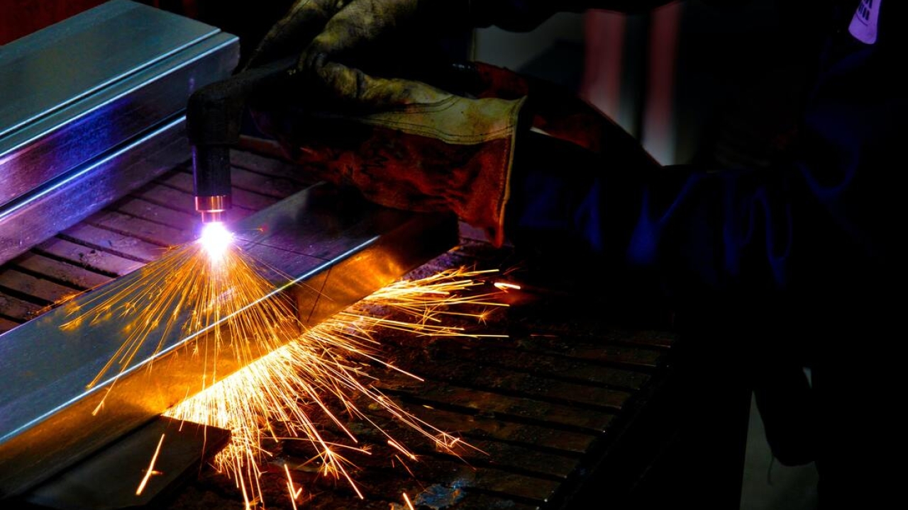 sparks fly as a student works on machinery