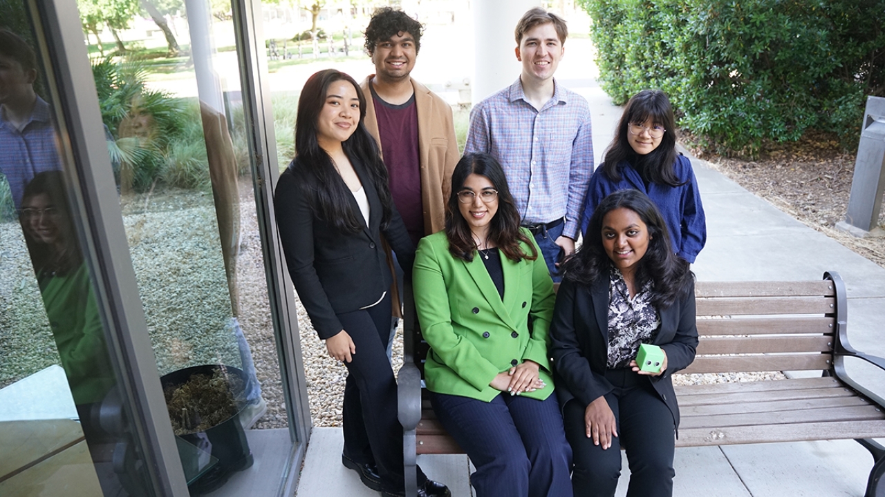 The Make Box team sit outdoors, two on a bench and four standing behind