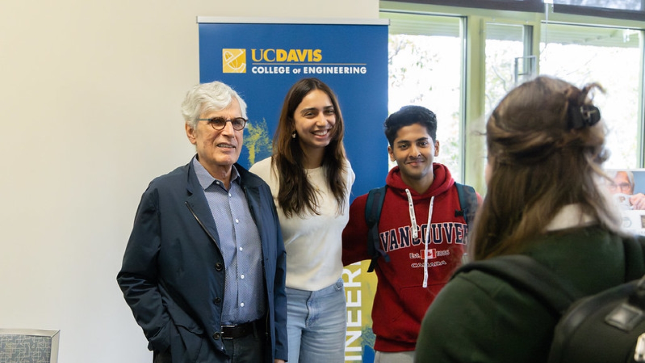 Jerry Baldwin stands with students in front of a College of Engineering banner