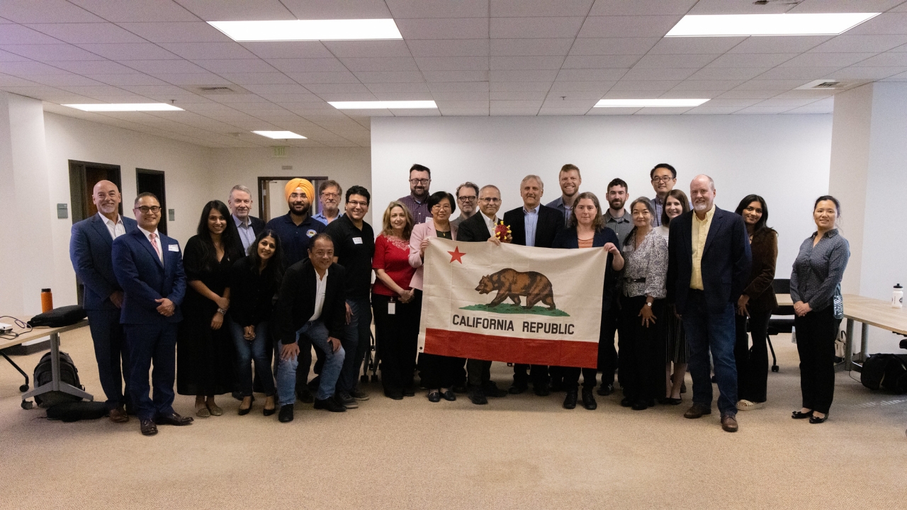 a large group of indoor air quality experts from uc davis college of engineering and the california department of public health holding up a flag for the state of california