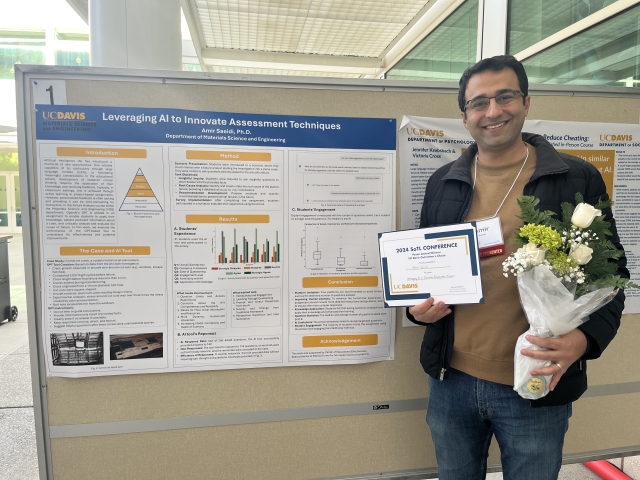 A man holds flowers and a certificate in front of a scientific presentation poster