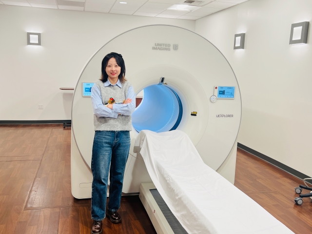 Xiaoyu Duan stands before a uEXPLORER total-body PET scanner