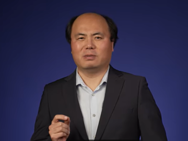 A professor speaking adamantly on a purple backdrop