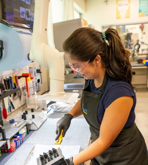 Quiroz holds equipment in lab
