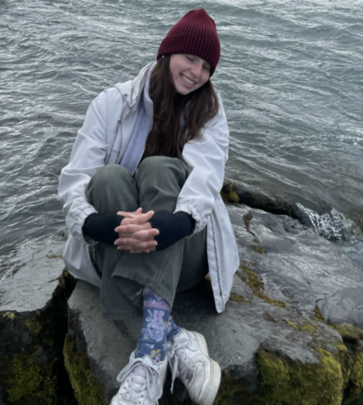 Woman sitting on a rock near a river or body of water