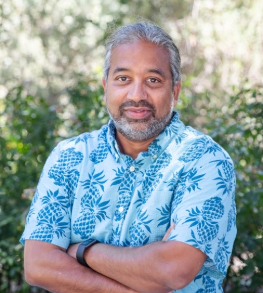 Sivasankar wearing a floral shirt, arms crossed, smiling outdoors