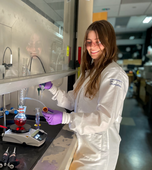Portrait of Hannah OToole in a lab environment wearing lab coat and other PPE