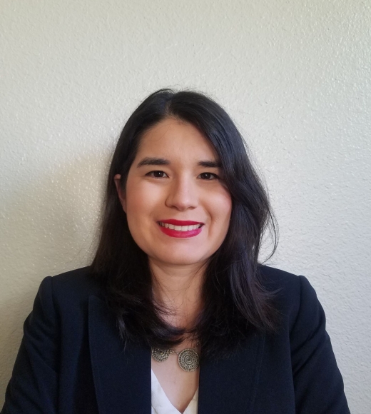 A Latinx woman wearing a white shirt and black blazer