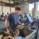 Student works on machinery in the Engineering Student Design Center at UC Davis