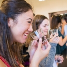 A woman tasting coffee from a tiny glass