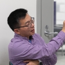 Professor Zhang wearing a collared shirt, talking with his hand outstreched