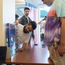 A student showing their project to a bystander