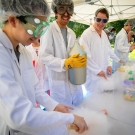 Three students in lab coats handling liquid nitrogen