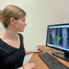 UC Davis grad student Abby Niesen sits at a desk with computer screen showing 3D imaging