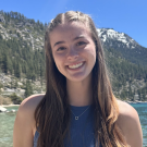 Charlotte smiling with a beach in the background
