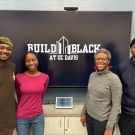 The Build Black Fellows and mentor Dawn McGee stand in front of the Build Black at UC Davis logo. 