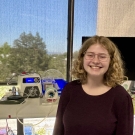 Kathleen Scott standing in front of a wearable breast pump machine