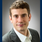 A portrait of a man wearing a suit against an all blue background