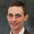 Professor Adam Moule against a gray backdrop