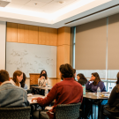 People closely gathered around tables in a lecture room